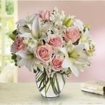 Reference T55-2A
Starting at $49.99
Full and fragrant, it gathers soft pink roses with white lilies, alstroemeria and mums into a rounded ginger vase.<br/>Light pink roses, white asiatic lilies, white alstroemeria and white cushion spray mums are mixed with white statice and variegated pittospordum.